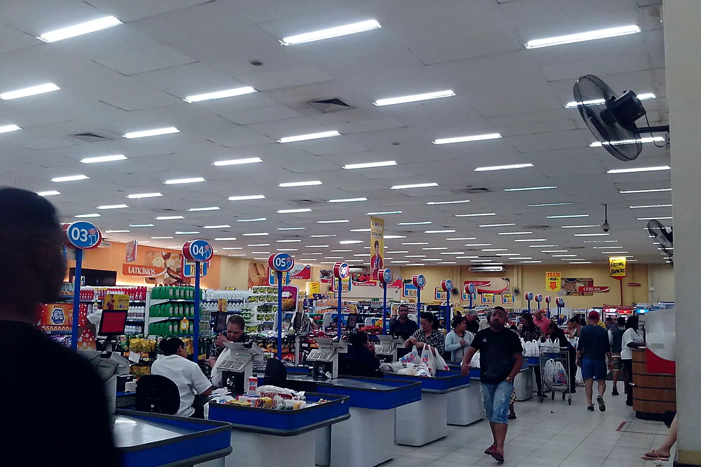 Frente de caixa de supermercado no Rio de Janeiro, com operadores e clientes passando as compras