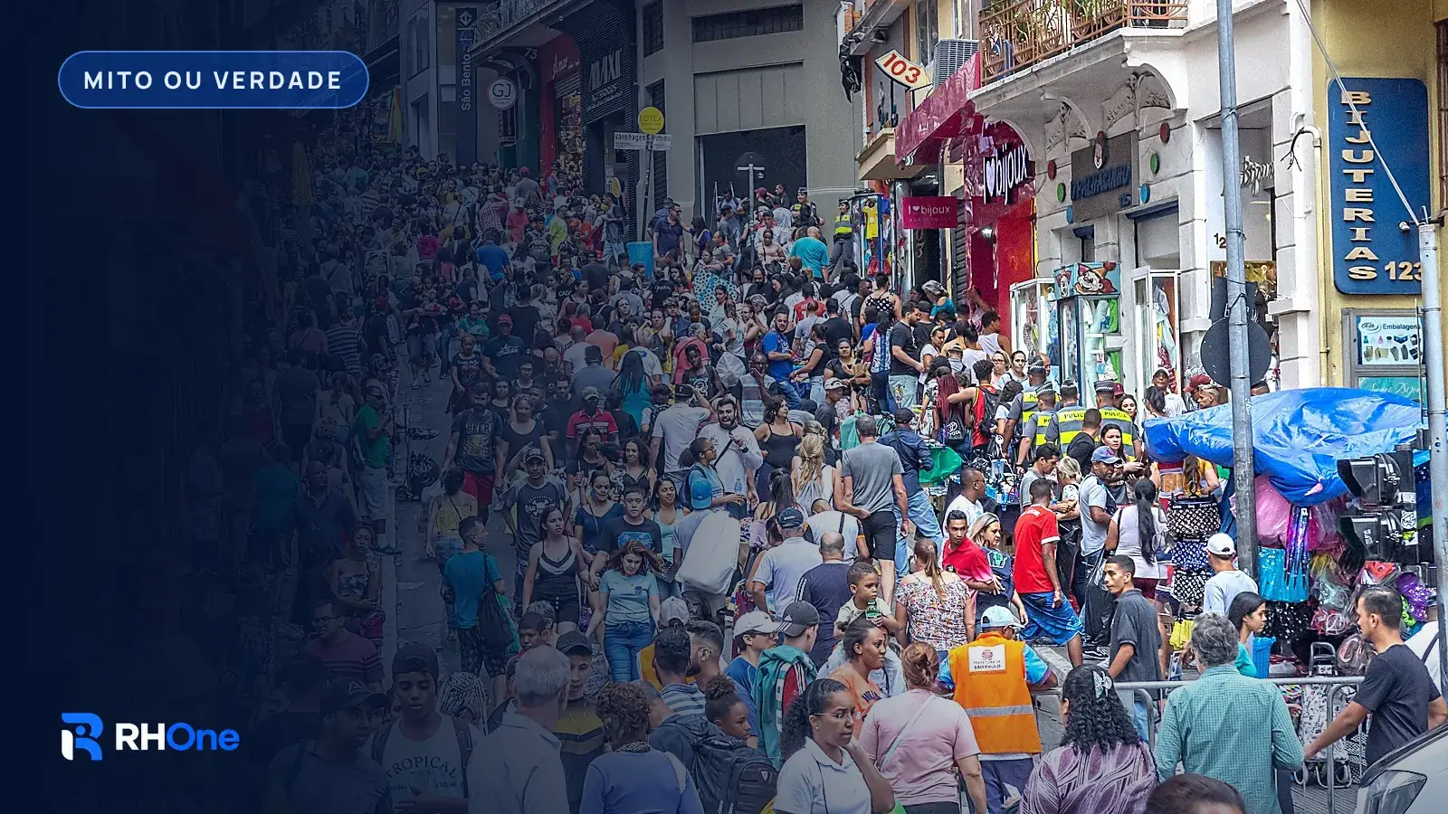 Multidão em rua de comércio popular no centro de São Paulo, com lojas, barracas de lona e letreiros em português