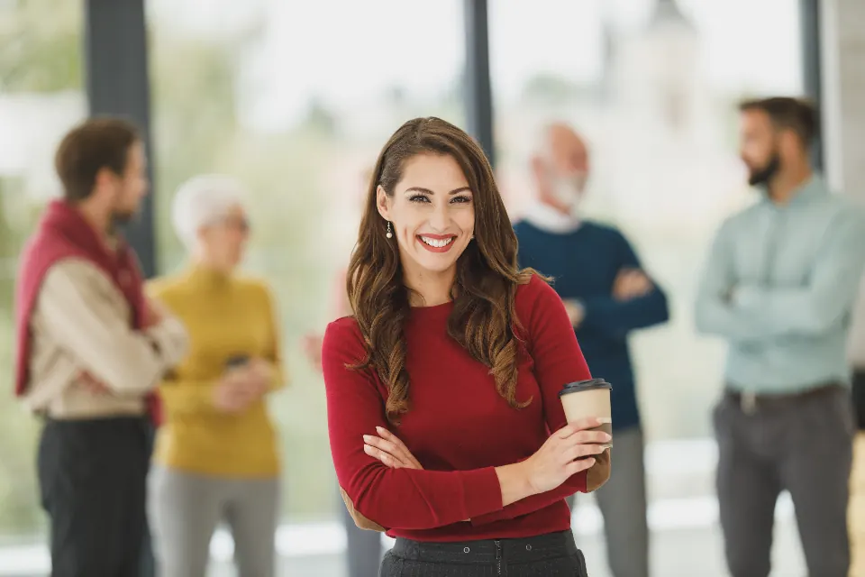 Dona de escritório contábil sorrindo com a equipe ao fundo
